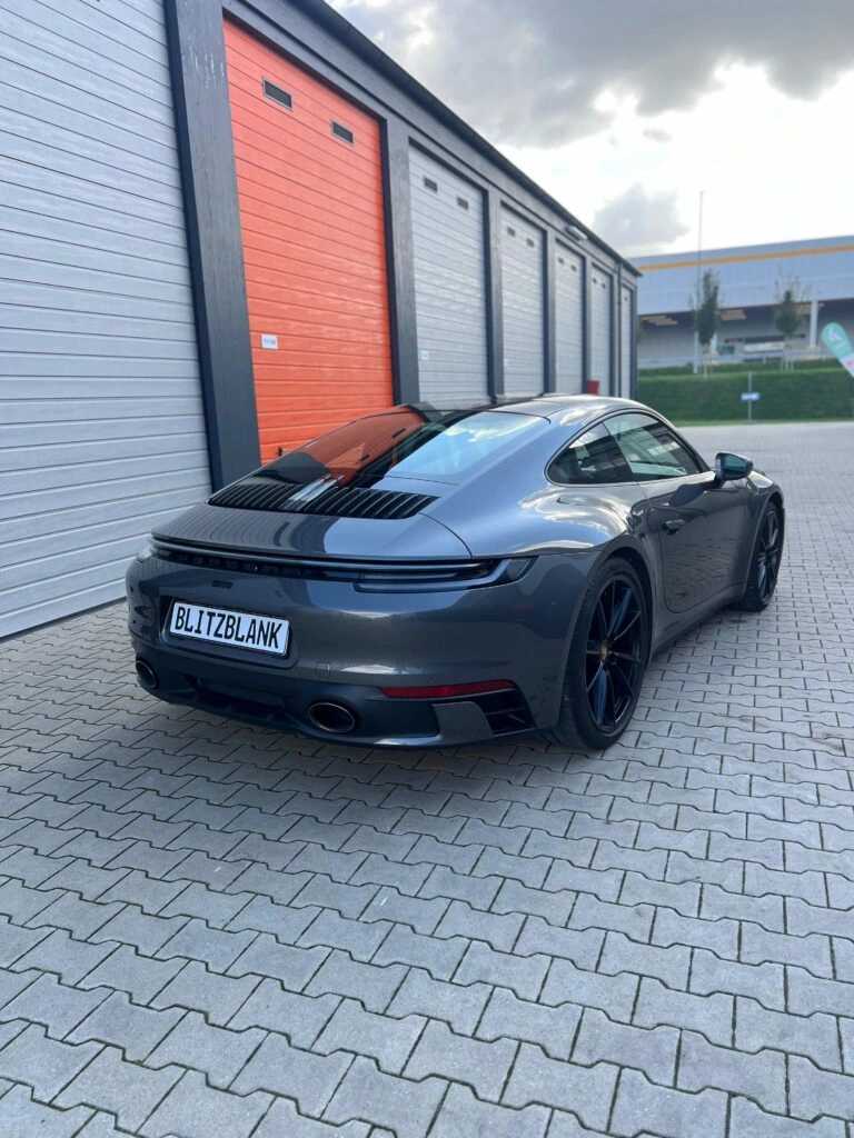 Porsche 911 Carrera in Grau nach der Fahrzeugaufbereitung, Heckansicht am Standort in Paderborn