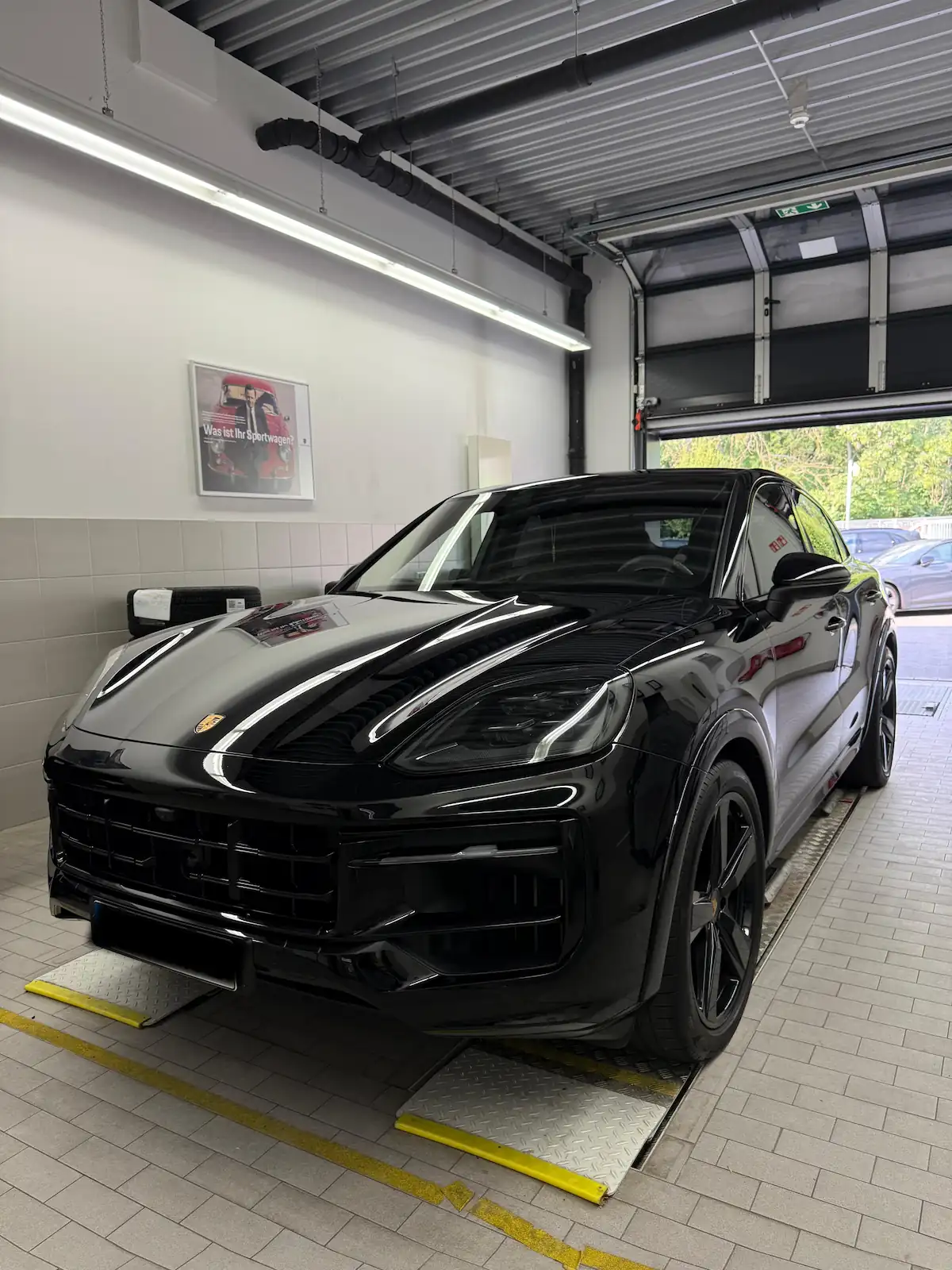Schwarzer Porsche Cayenne auf der Hebebühne nach der Fahrzeugaufbereitung
