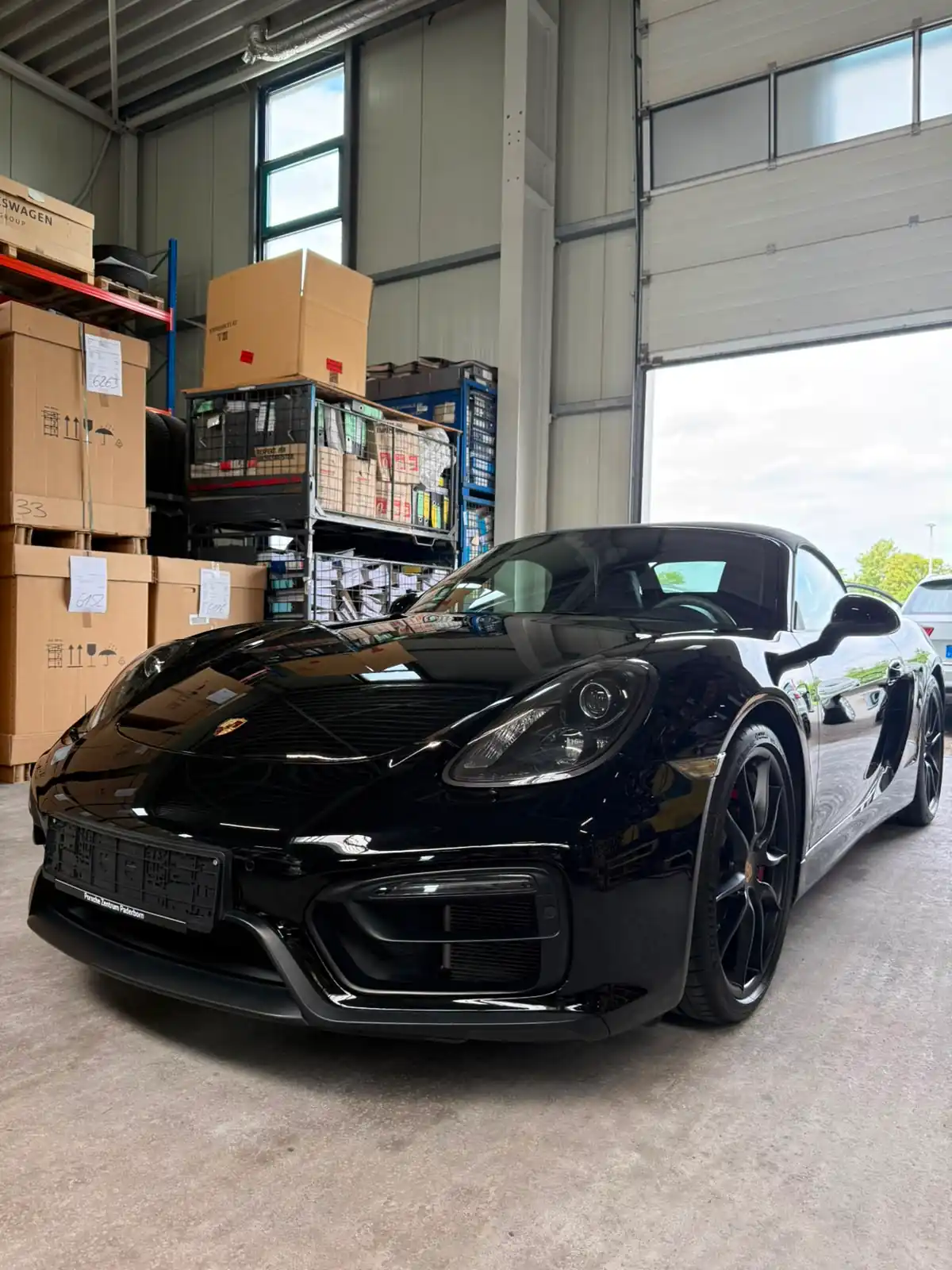 Schwarzer Porsche Cayman GTS nach der Fahrzeugaufbereitung mit glänzendem Lack